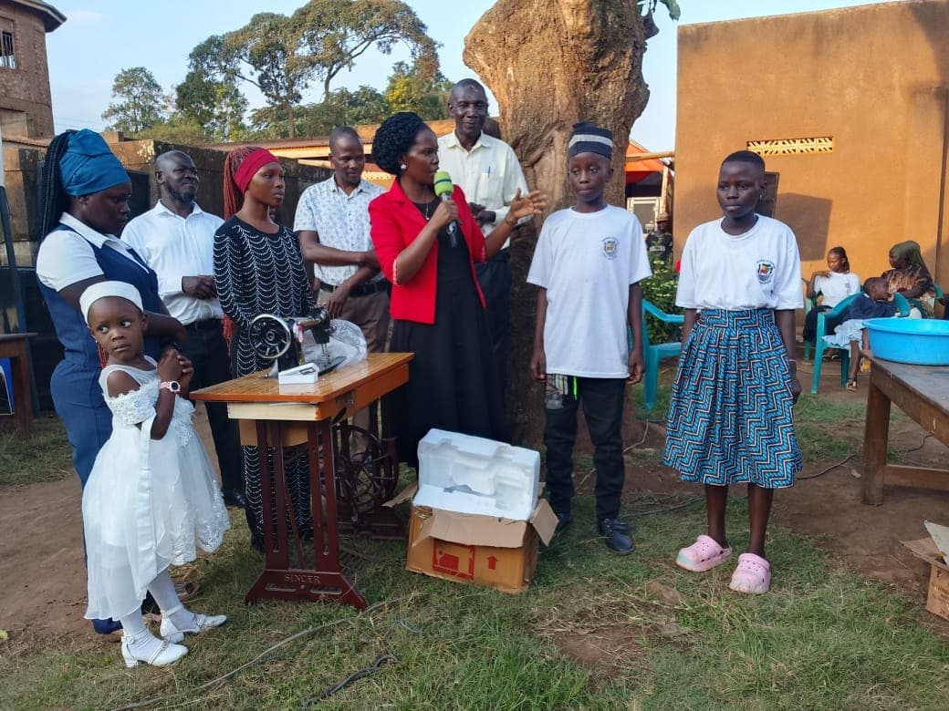 A sewing machine handover at a community gathering.