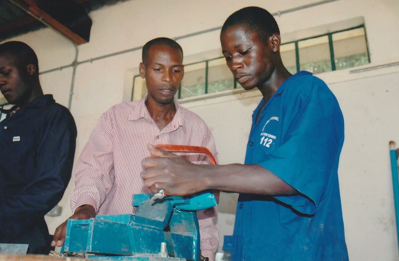Trainees examine a piece of workshop equipment.